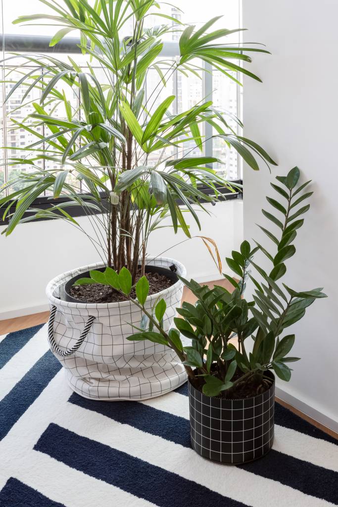 Painel e rack de TV separam living de home office em apê de 75m². Projeto de ISE Arquitetura. Na foto, plantas com cachepot de tecido.