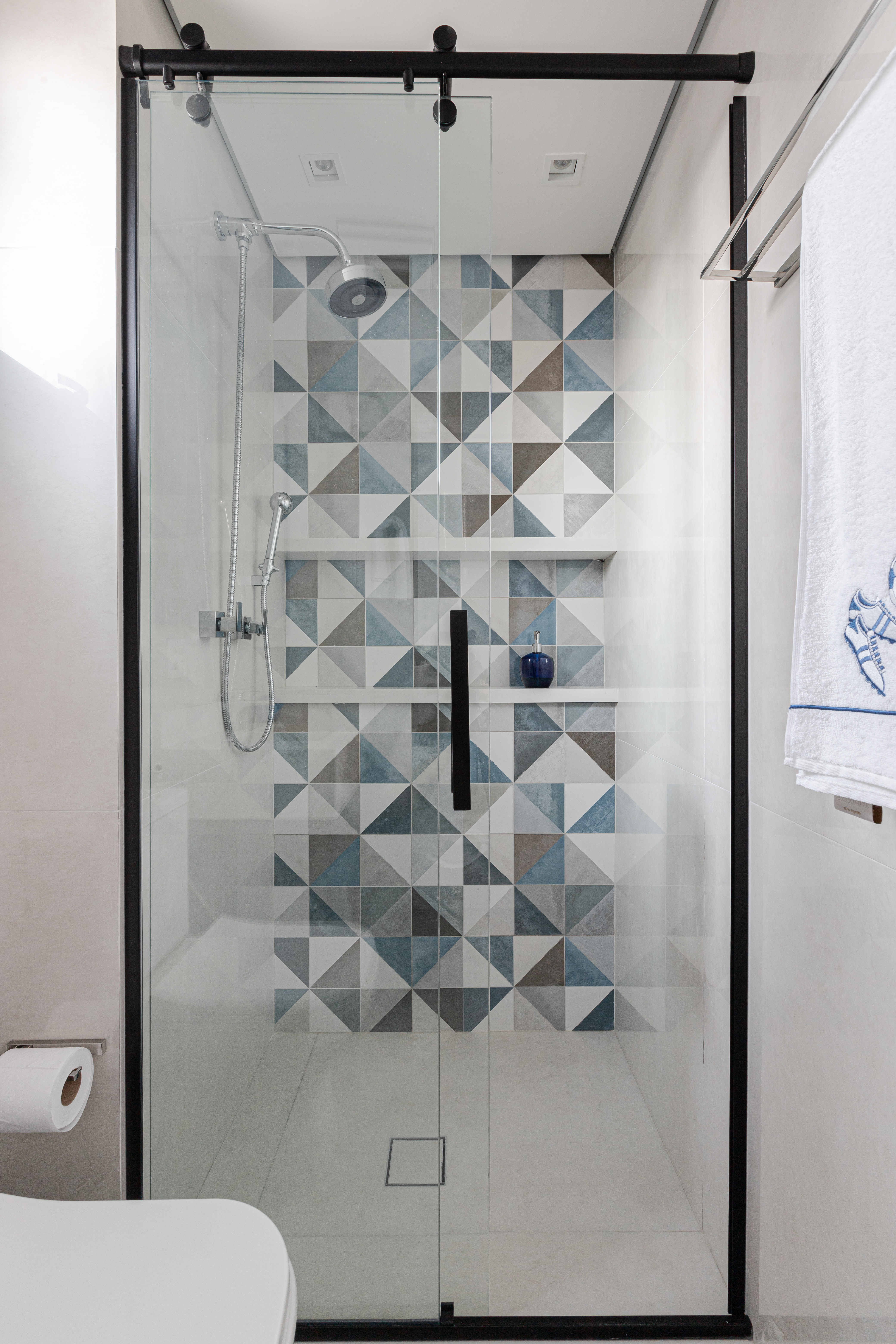 Reforma em apê de 140m² transforma banheiro em biblioteca de home office. Projeto de Blaia e Moura Arquitetos. Na foto, banheiro com azulejos geométricos coloridos.