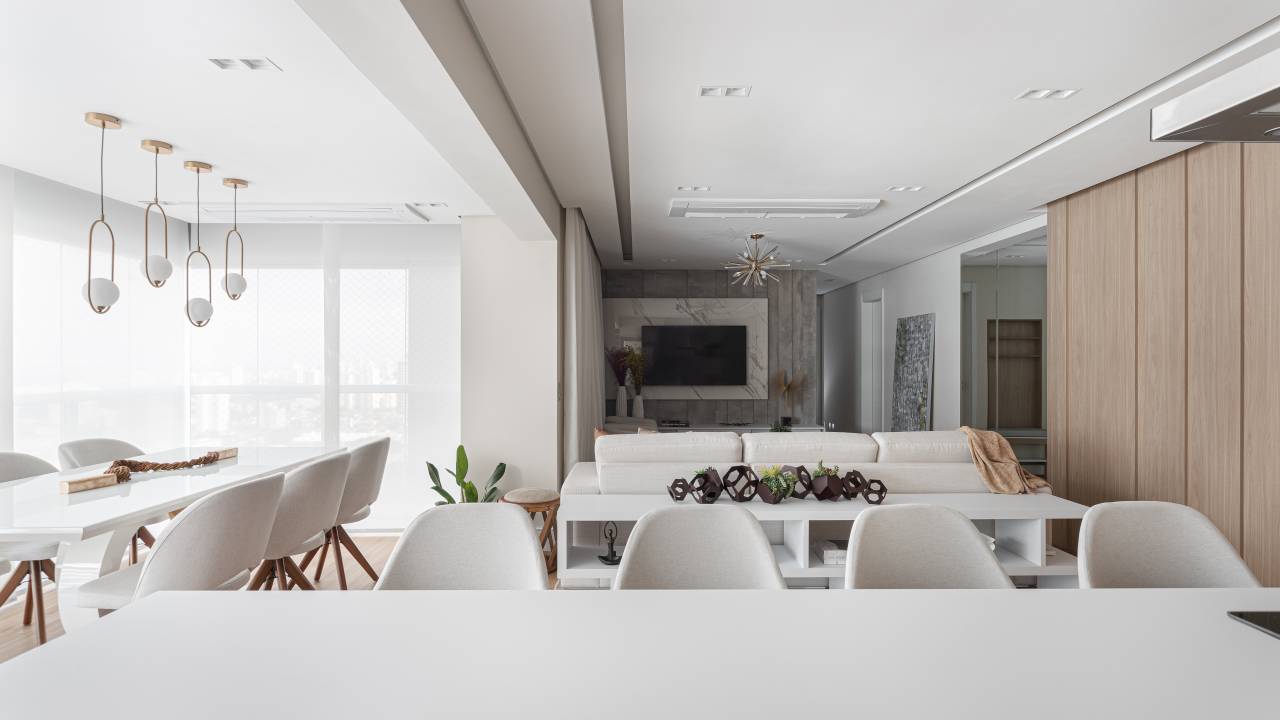 Reforma em apê de 140m² transforma banheiro em biblioteca de home office. Projeto de Blaia e Moura Arquitetos. Na foto, sala de estar integrada com jantar, cozinha e varanda gourmet.
