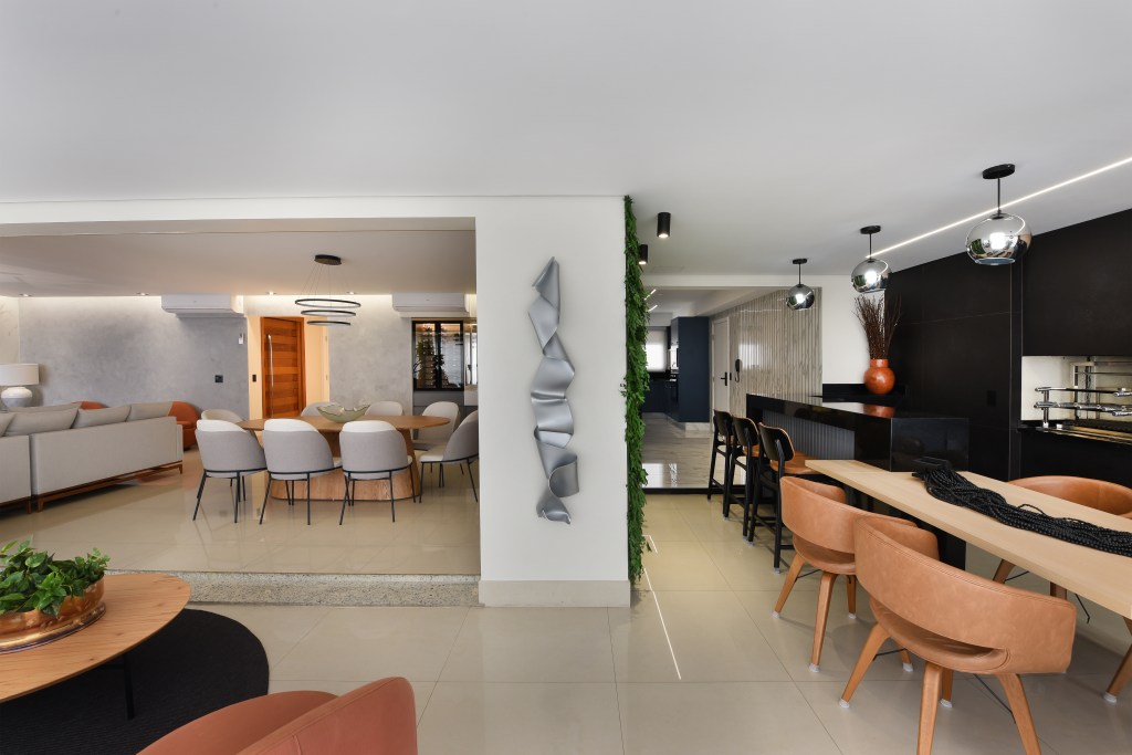 Reforma em apê de 204m² cria área gourmet com mix de granito e MDF. Projeto de AB Palacios Arquitetura. Na foto, sala de estar integrada com jantar e varanda gourmet.