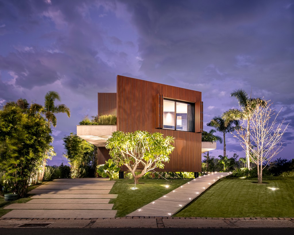 A água é destaque nesta casa de 457 m² no Rio Grande do Sul. Projeto de Stemmer Rodrigues. Na foto, fachada com jardim.