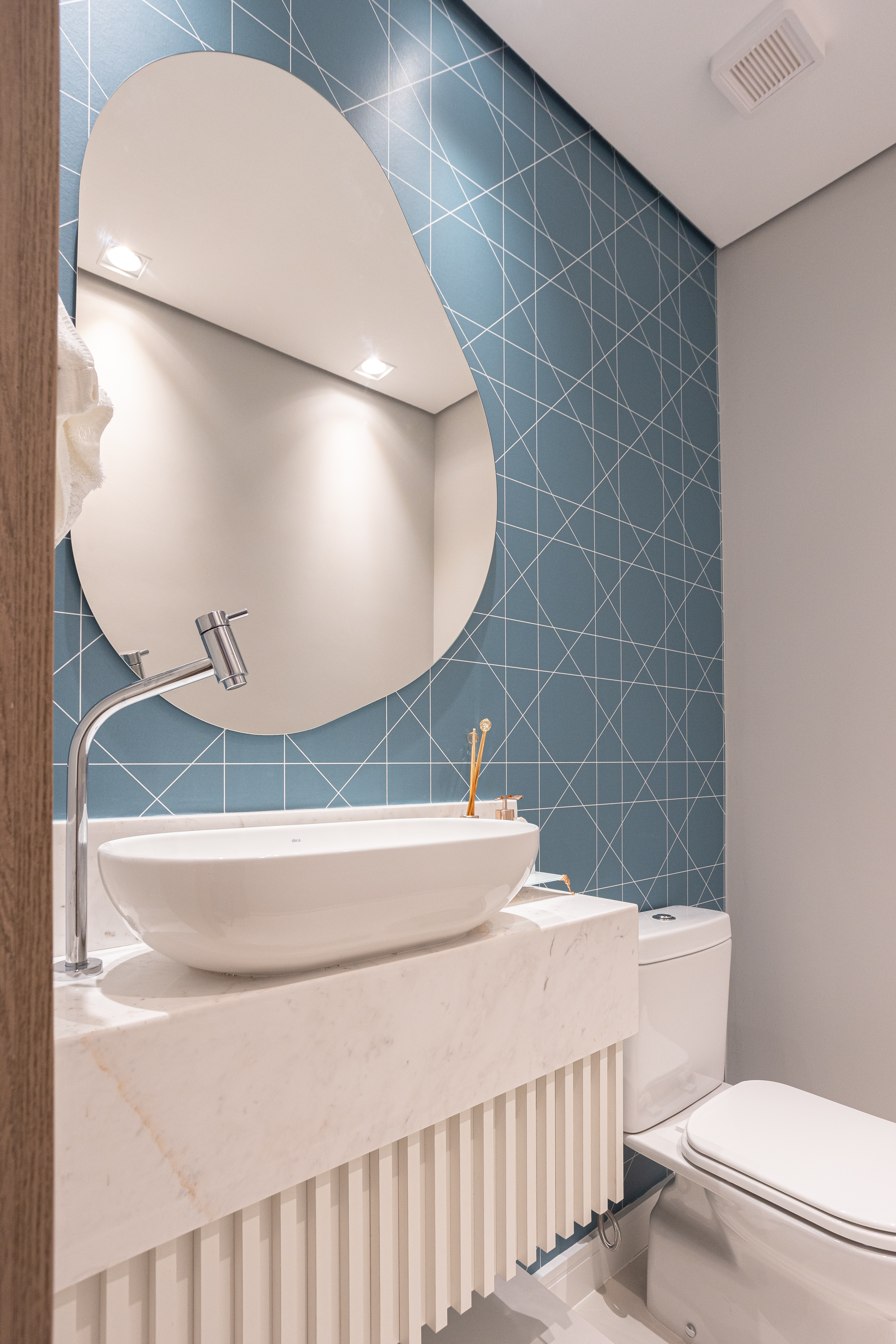 Apartamento de 140 m² possui parede de pedra moledo e quarto montessoriano. Projeto Loft 7 Arquitetura. Na foto, lavabo com espelho orgânico e papel de parede.