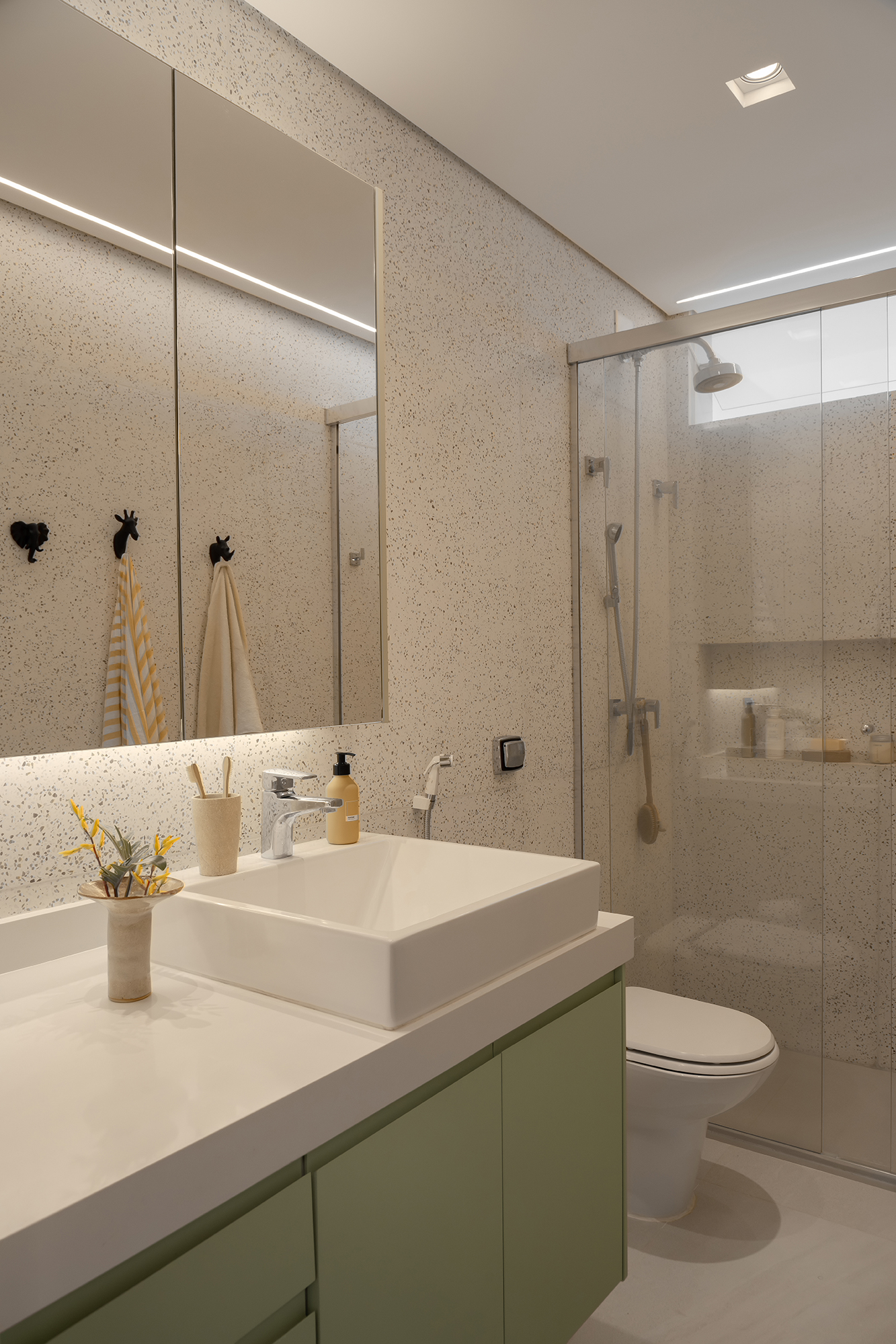 Apartamento de 188 m² ganha dois cooktops na cozinha e balanços na sala, Projeto Raízes Arquitetos. Na foto, banheiro com marcenaria verde.