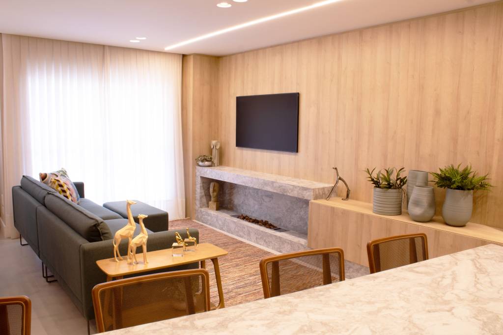 Apartamento de 80 m² ganha lareira a gás e parede marsala na sala. Projeto do arquiteto Felippe Comninos, à frente da Vale Arquitetura, em parceria com a arquiteta Adriana Marcassa Cotrin, do escritório Marcassa Cotrin. Na foto, sala com tv e lareira a gás.