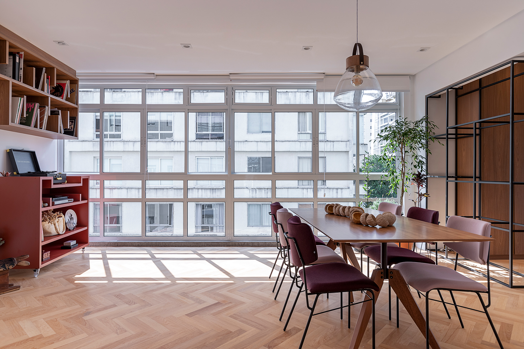 Apartamento dos anos 1950 une charme, história e cores em 128 m². Projeto de Ju Matos Arquitetura. Na foto, sala de estar e jantar com janelão e piso de escama de peixe.