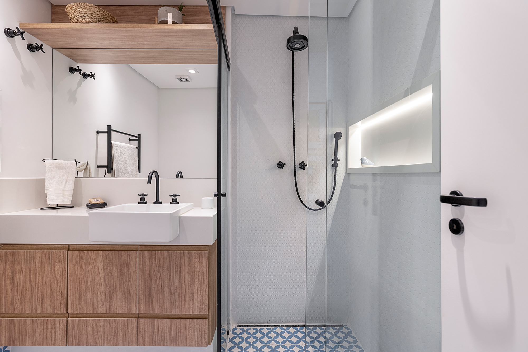 Apartamento dos anos 1950 une charme, história e cores em 128 m². Projeto de Ju Matos Arquitetura. Na foto, banheiro com piso geométrico azul e box de serralheria.