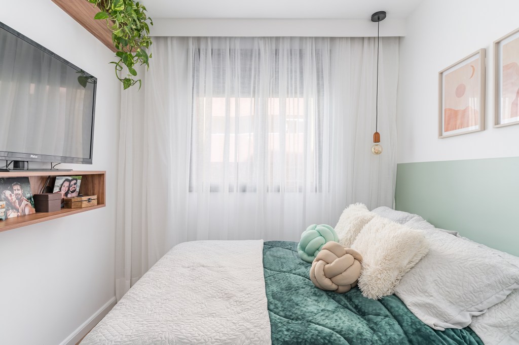 Apê de 62 m² une estilo praiano com toques industriais. Projeto de Letícia de Nóbrega. Na foto, quarto com meia-parede verde e quadros.