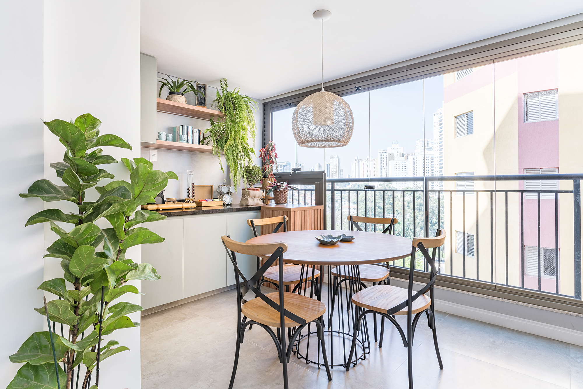 Apê de 62 m² une estilo praiano com toques industriais. Projeto de Letícia de Nóbrega. Na foto, varanda com canto do café, mesa de refeições e plantas.