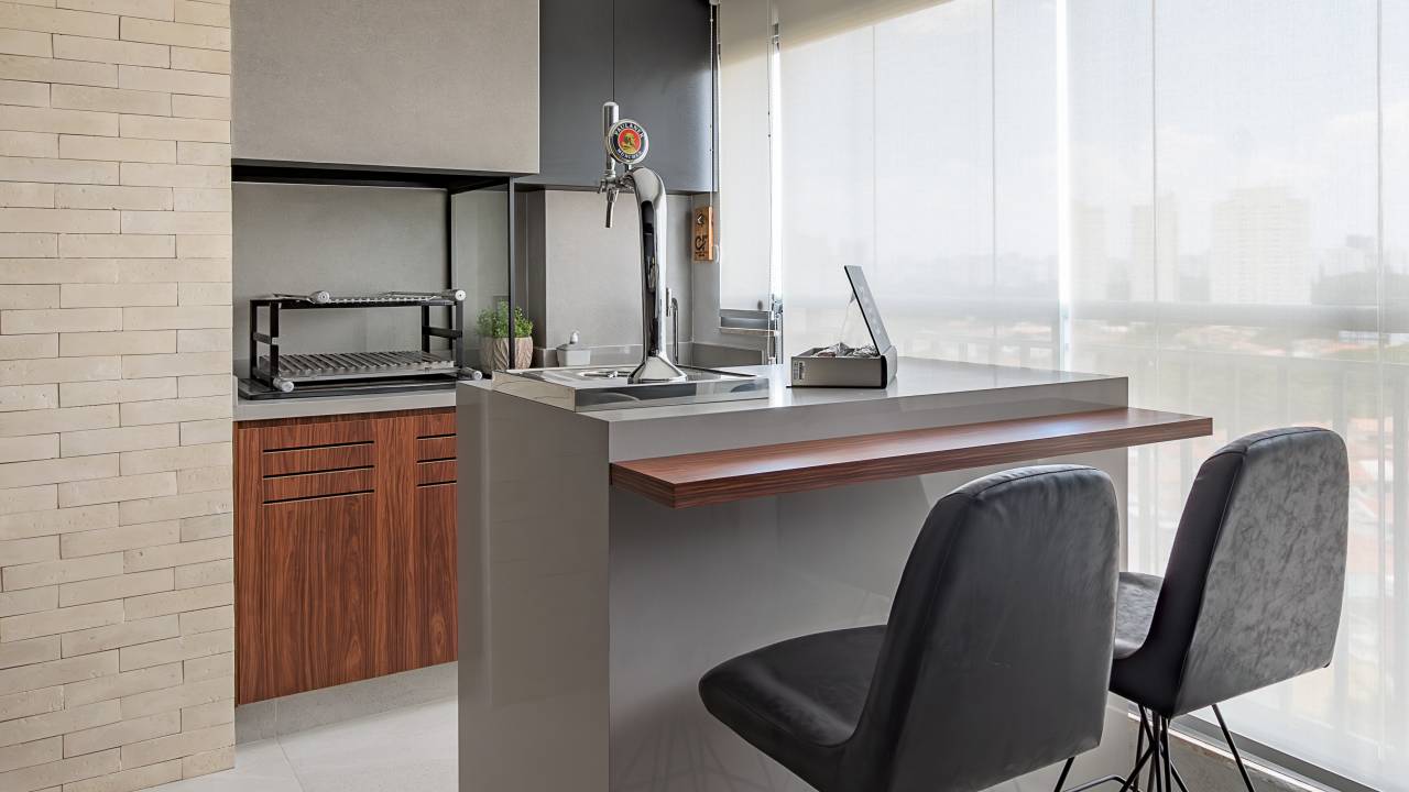 Apê de 79 m² tem cantinho com cervejeira na varanda e penteadeira. Projeto de Vitoria Lacerda Arquitetura. Na foto, varanda integrada com ilha, chopeira e banquetas.