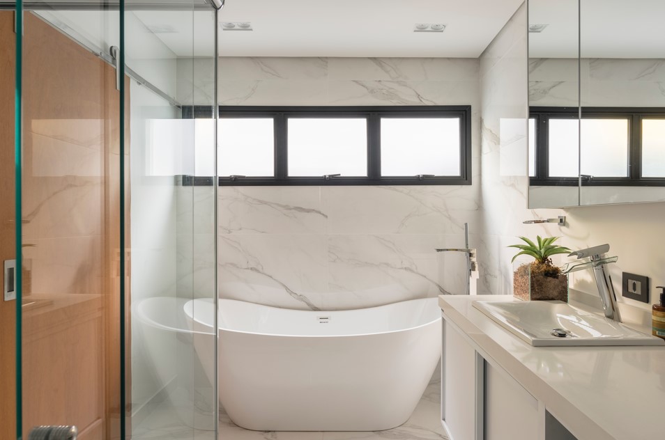 Banheiros: dicas para renovar cubas, bancada, metais, piso e rejuntamento. Projeto de PB Arquitetura. Na foto, banheiro com revestimento marmorizado e banheira solta.