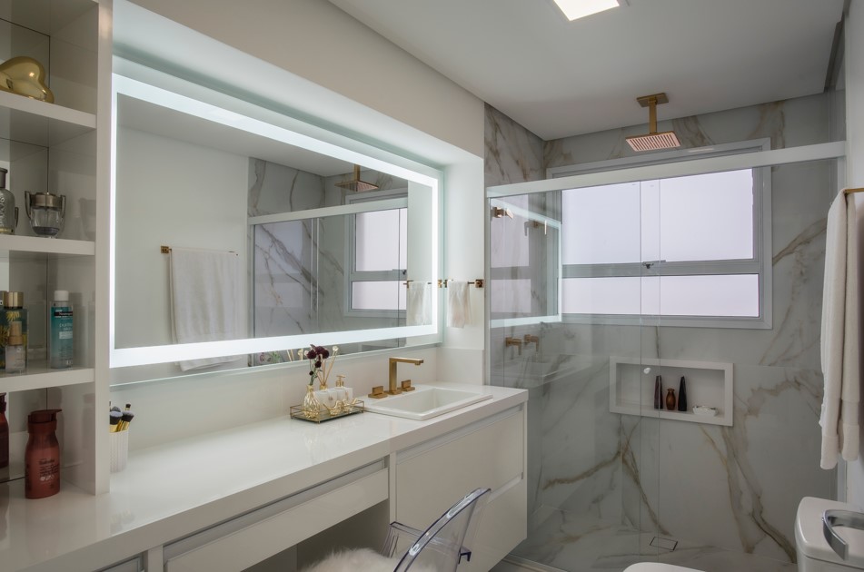 Banheiros: dicas para renovar cubas, bancada, metais, piso e rejuntamento. Projeto de PB Arquitetura. Na foto, banheiro com revestimento marmorizado e espelho iluminado com led.