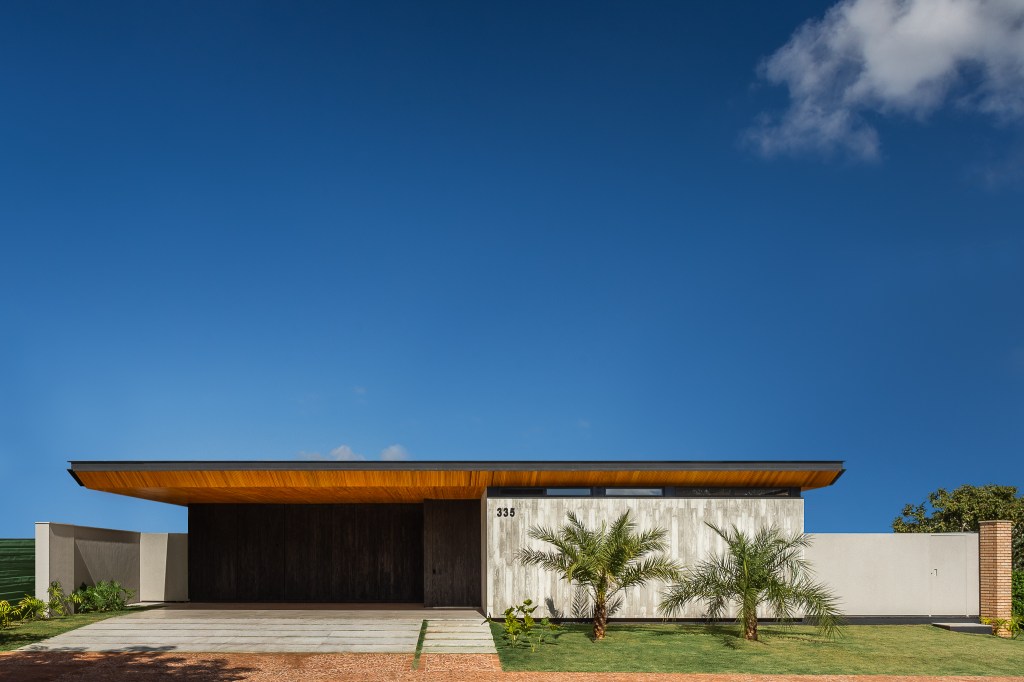 Casa de 379 m² une arquitetura minimalista e integração com o entorno. Projeto Camila Porto. Na foto, fachada com vista para o jardim.