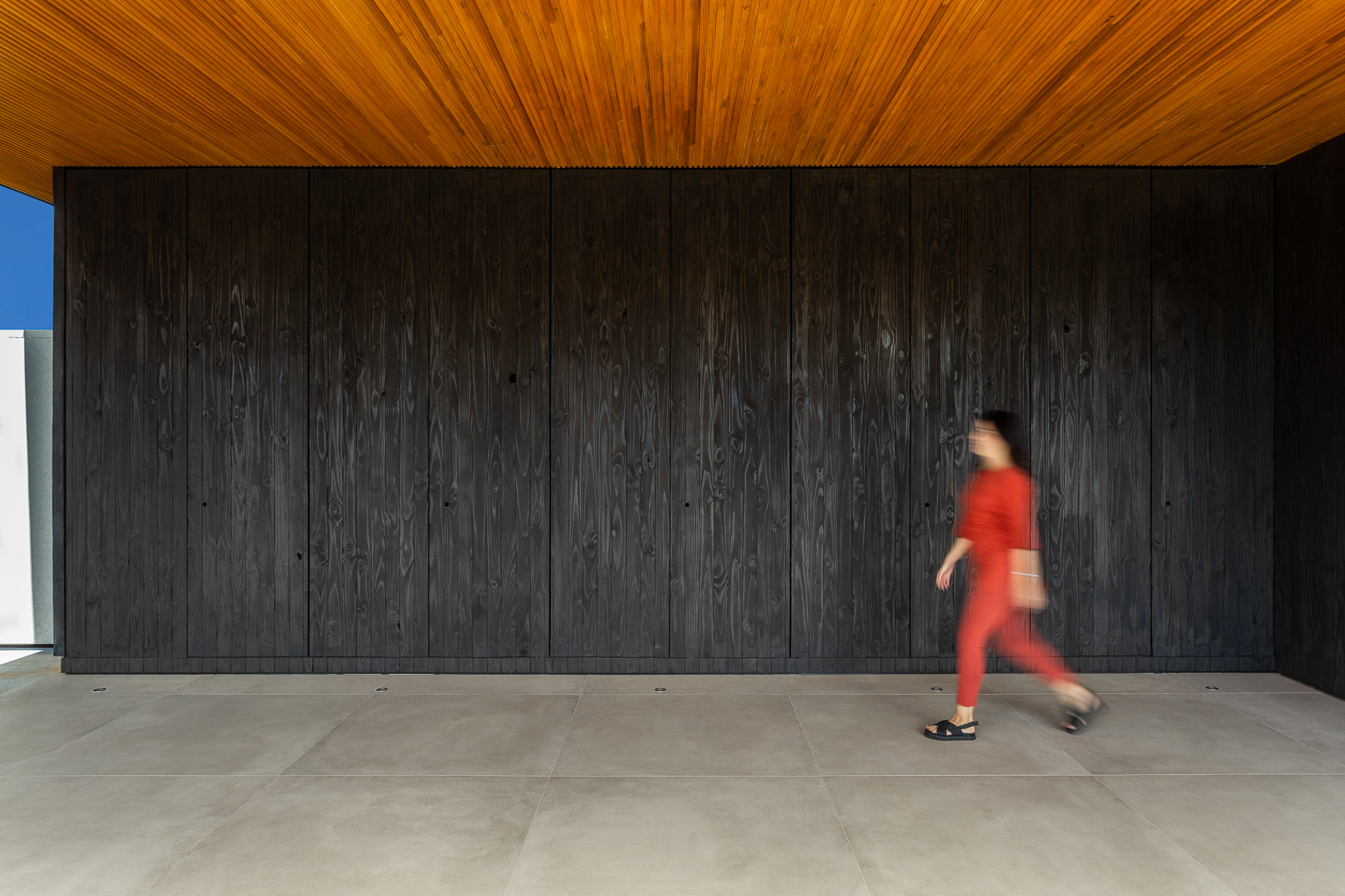 Casa de 379 m² une arquitetura minimalista e integração com o entorno. Projeto Camila Porto. Na foto, parede de shou sugi ban.