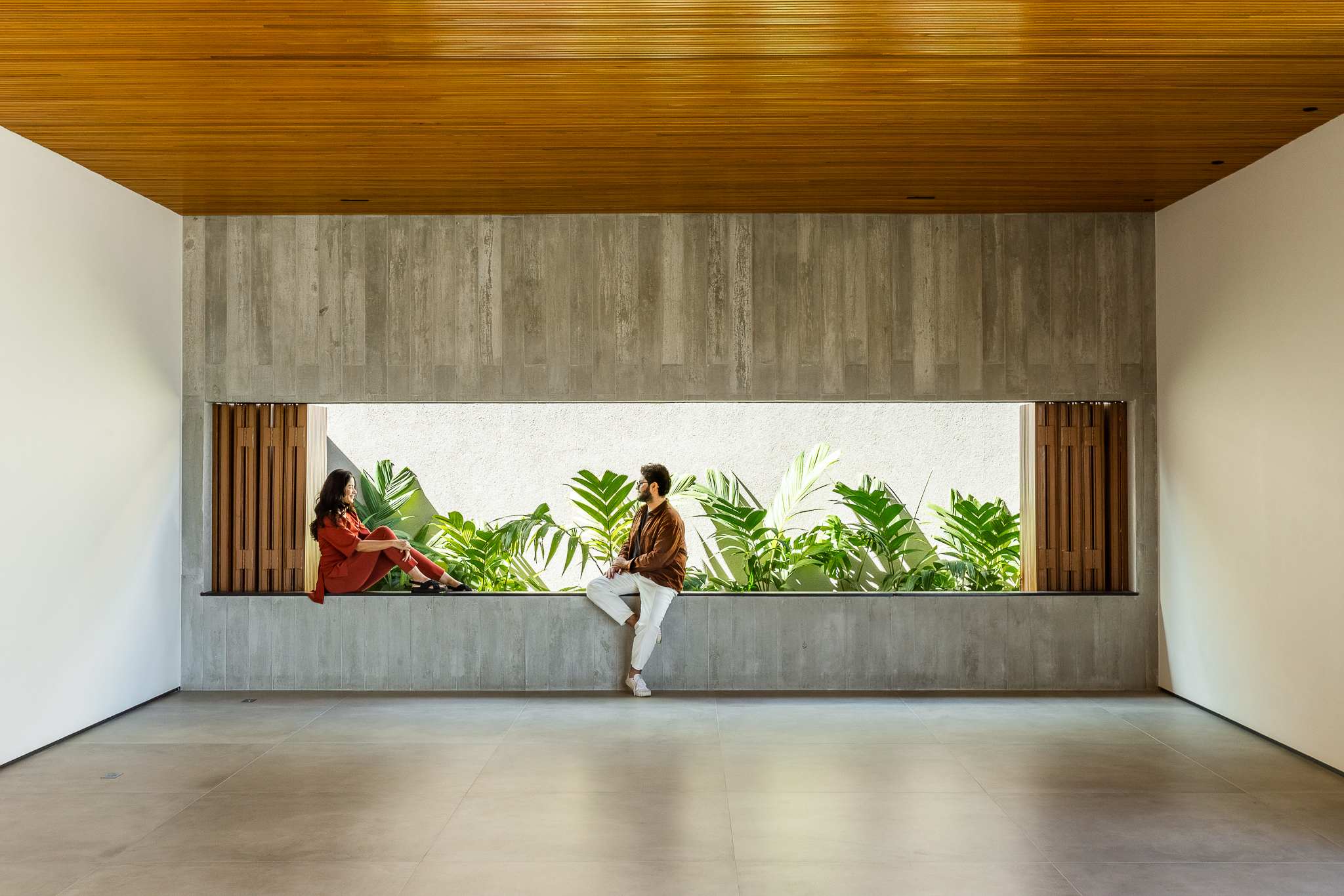 Casa de 379 m² une arquitetura minimalista e integração com o entorno. Projeto Camila Porto. Na foto, abertura na arquitetura com vista para o jardim.