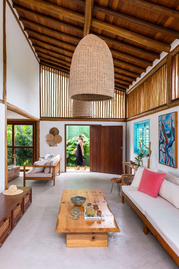 Casa em Trancoso é inspirada na arquitetura colonial do sul da Bahia. Projeto Conrado Ceravolo. Na foto, sala com esquadria azul e móveis rústicos.