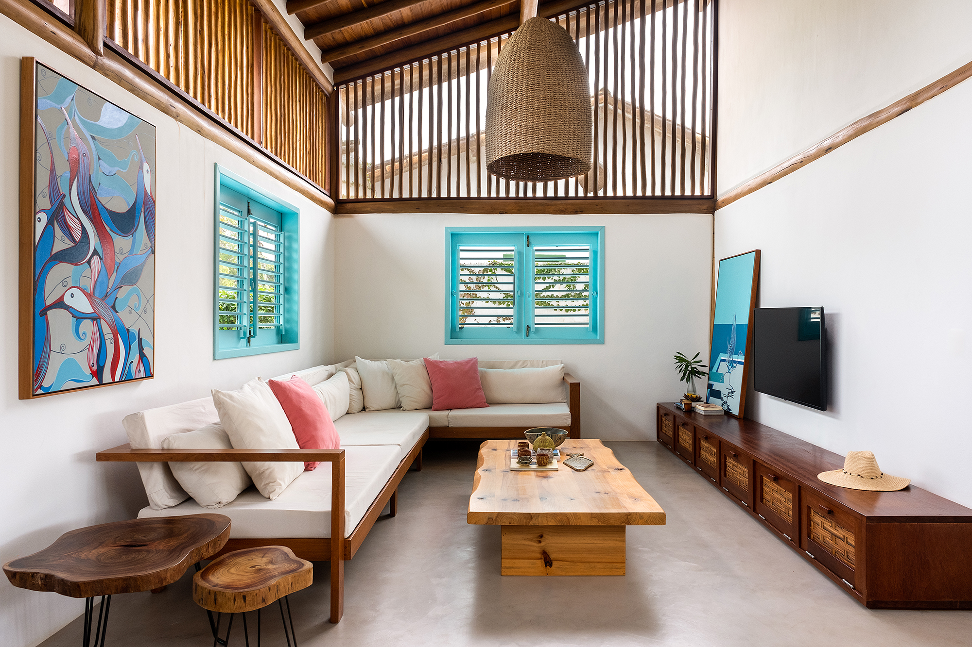 Casa em Trancoso é inspirada na arquitetura colonial do sul da Bahia. Projeto Conrado Ceravolo. Na foto, sala com esquadria azul e móveis rústicos.