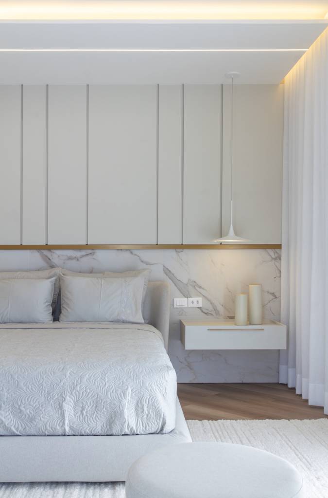 Casa do zagueiro da seleção Gleison Bremer tem estilo minimalista elegante. Projeto de Daniel Santana. Na foto, quarto minimalista com meia parede com revestimento de porcelanato marmorizado.
