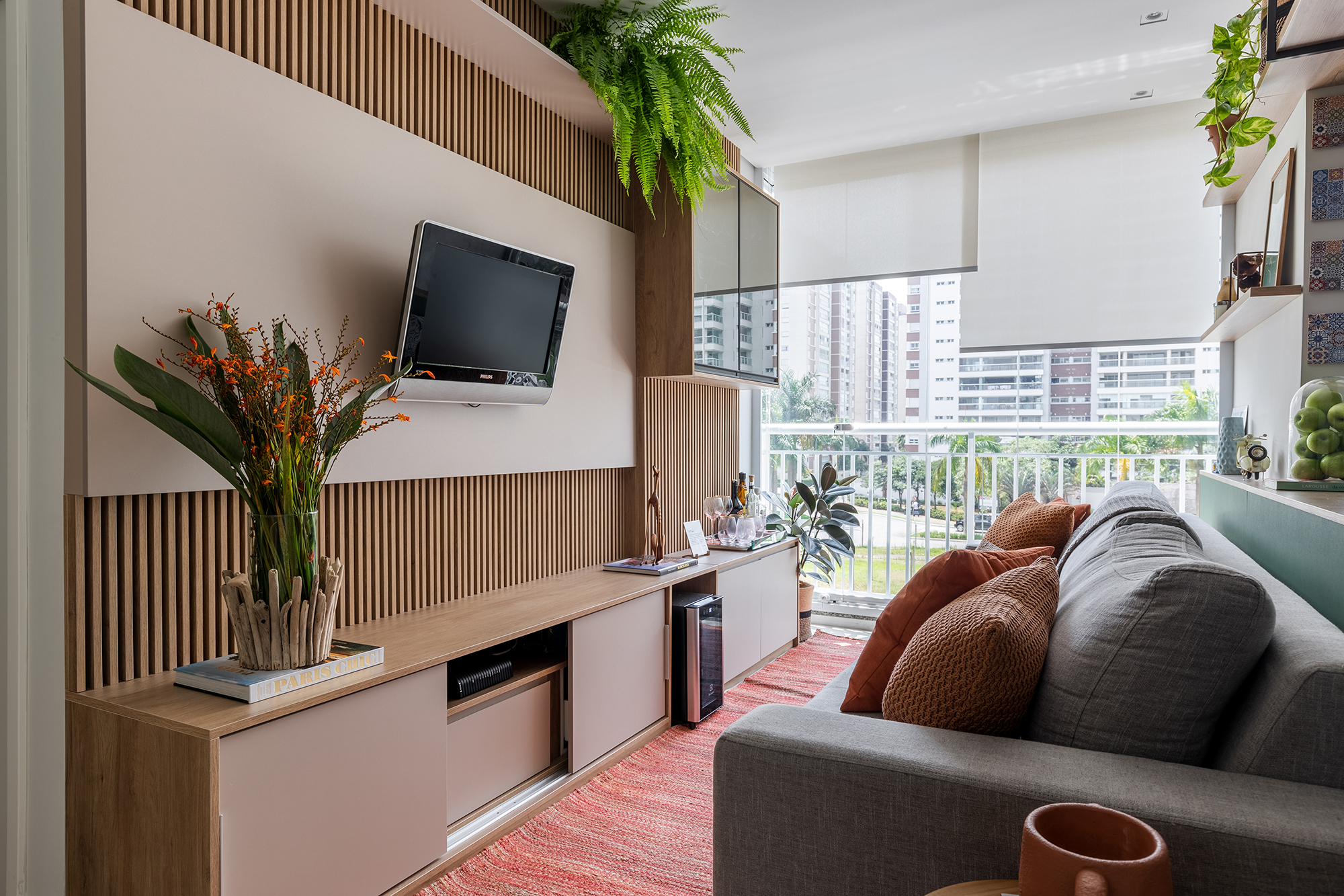 Cozinha verde e granilite no banheiro marca apartamento de 58 m². Projeto de Pixel Arquitetura. Na foto, sala com painel de TV ripado e varanda integrada,