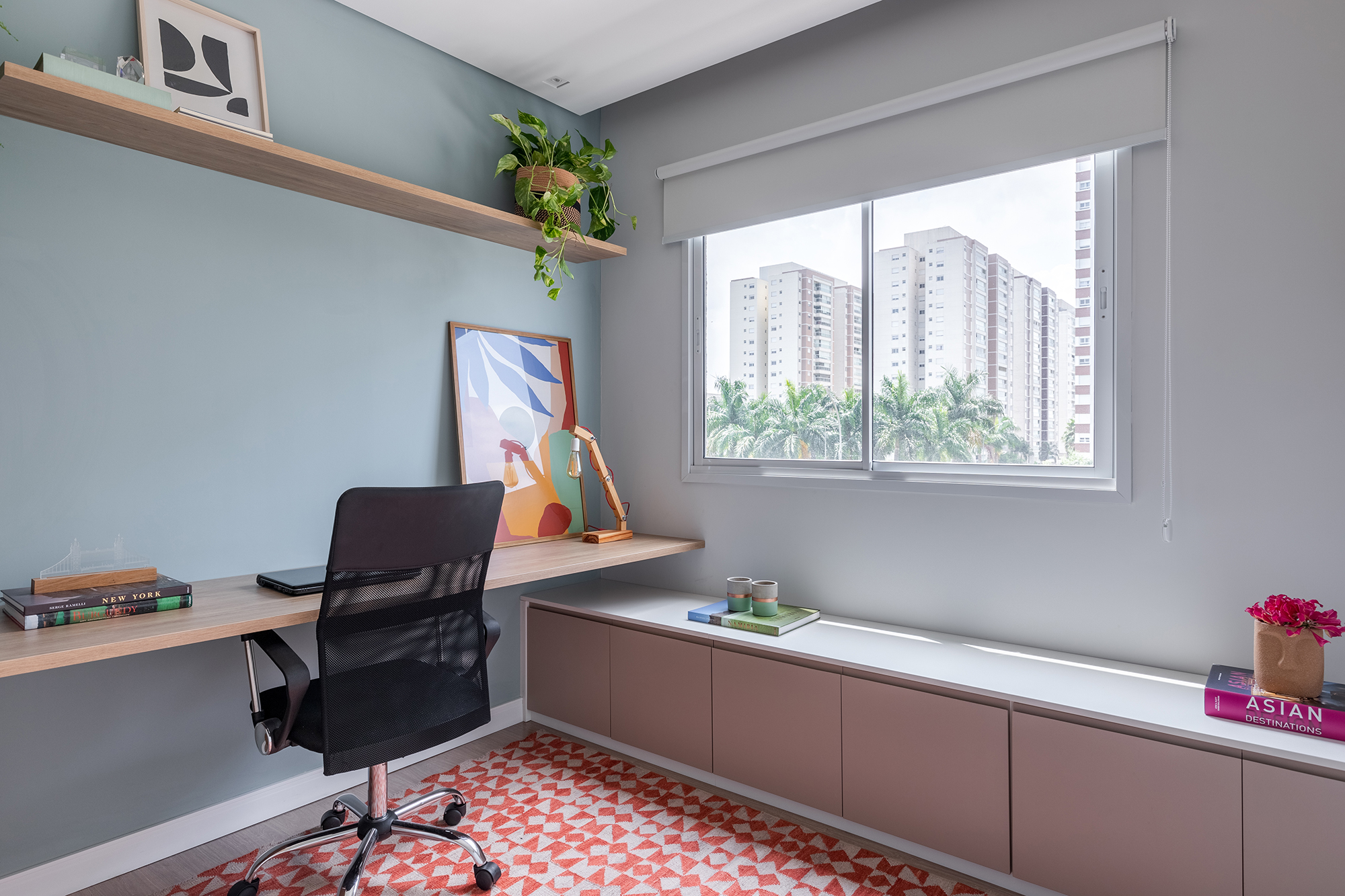 Cozinha verde e granilite no banheiro marca apartamento de 58 m². Projeto de Pixel Arquitetura. Na foto, home office com bancada integrada ao armário. Tapete com estampa geométrica.