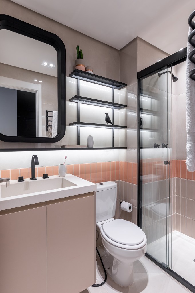Cozinha verde e granilite no banheiro marca apartamento de 58 m². Projeto de Pixel Arquitetura. Na foto, banheiro com boxe de serralheria e revestimentos rosas.