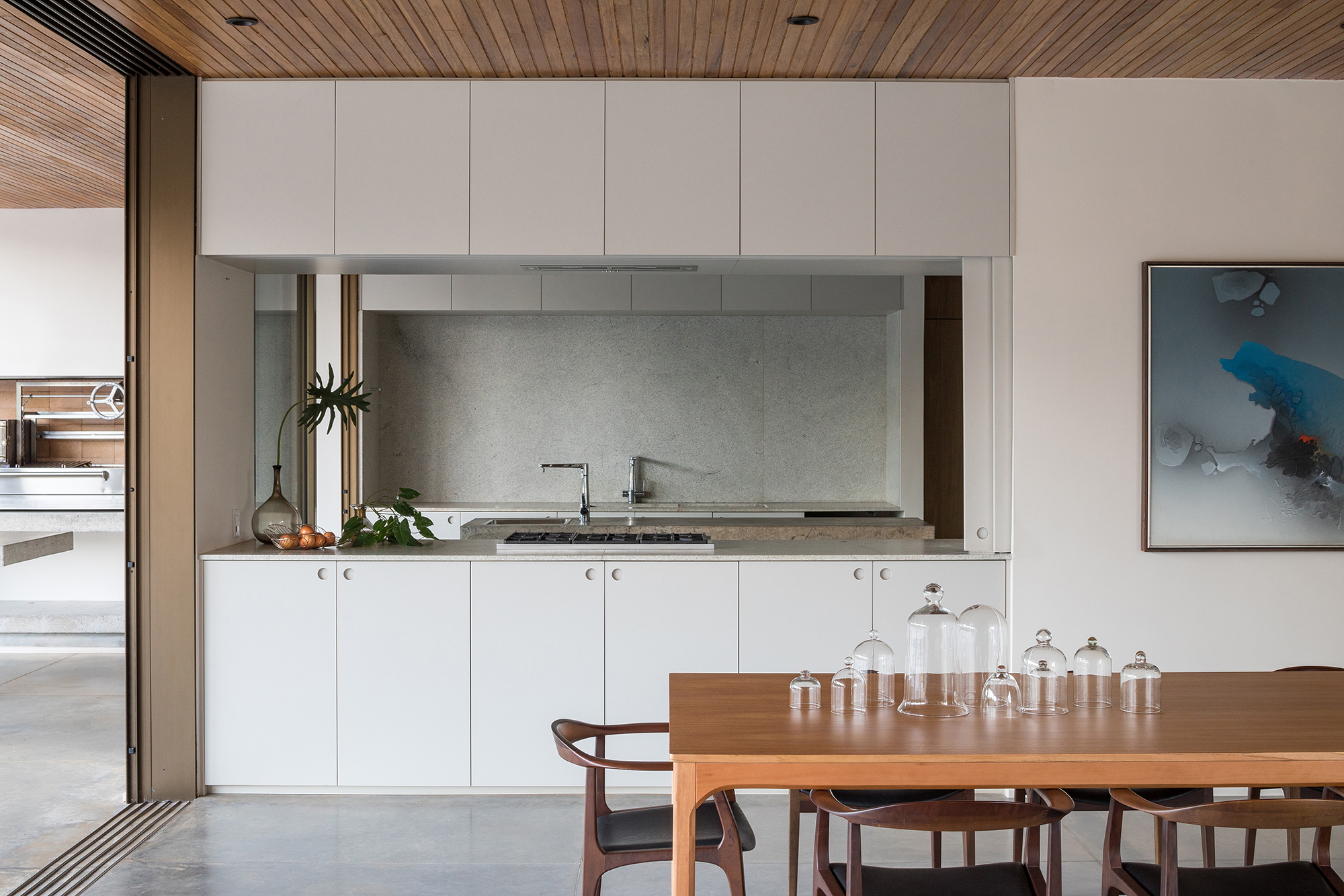 Dois volumes sobrepostos compõem esta casa de 500 m² em Brasília. Projeto de Bloco Arquitetos. Na foto, cozinha com bancada de concreto e armários.