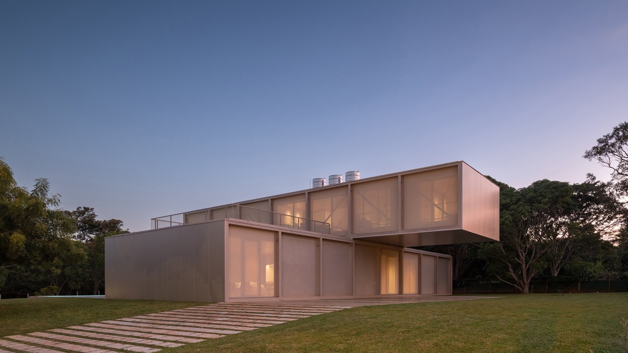 Dois volumes sobrepostos compõem esta casa de 500 m² em Brasília. Projeto de Bloco Arquitetos. Na foto, fachada com jardim.