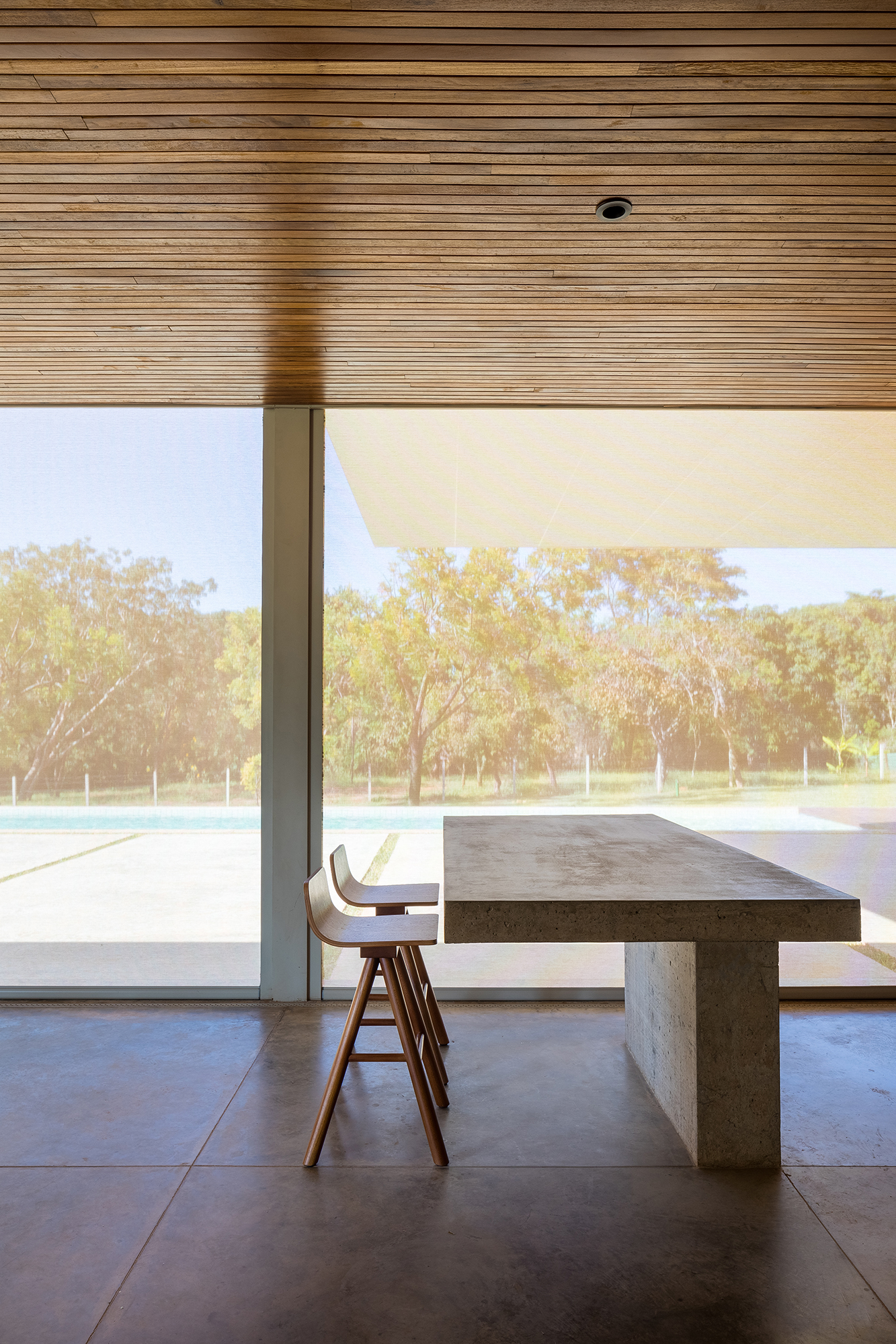 Dois volumes sobrepostos compõem esta casa de 500 m² em Brasília. Projeto de Bloco Arquitetos. Na foto, sala de jantar com vista para a varanda com piscina.