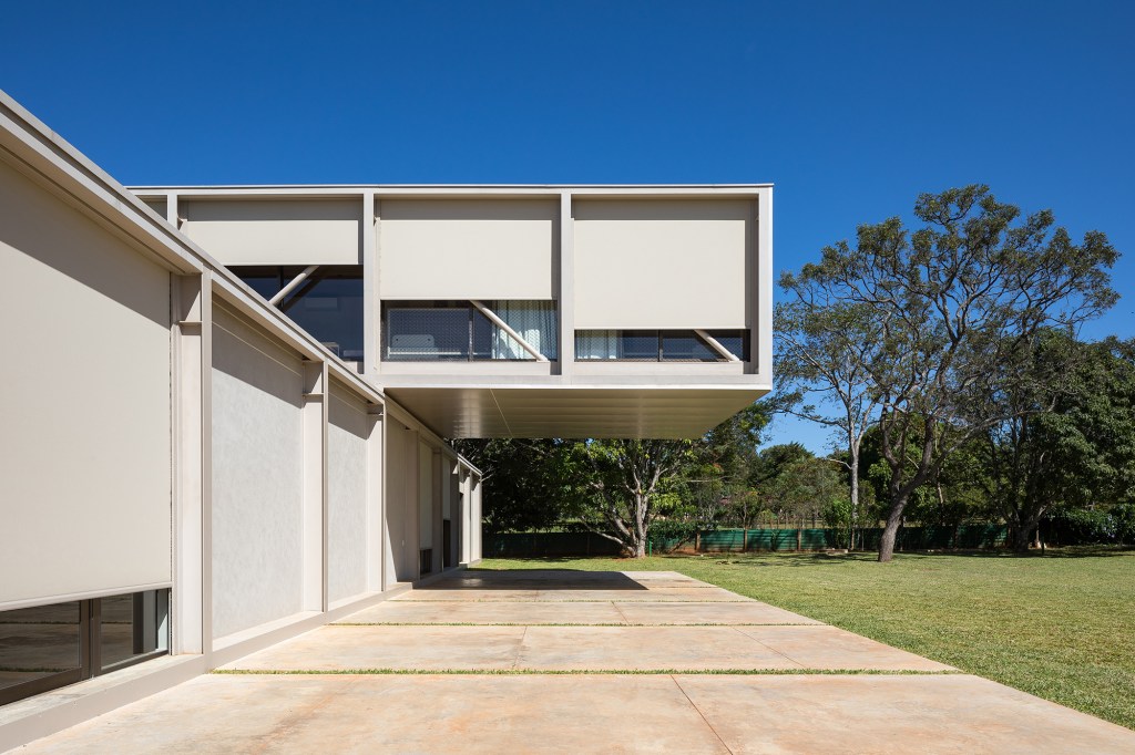 Dois volumes sobrepostos compõem esta casa de 500 m² em Brasília. Projeto de Bloco Arquitetos. Na foto, fachada da casa com jardim.