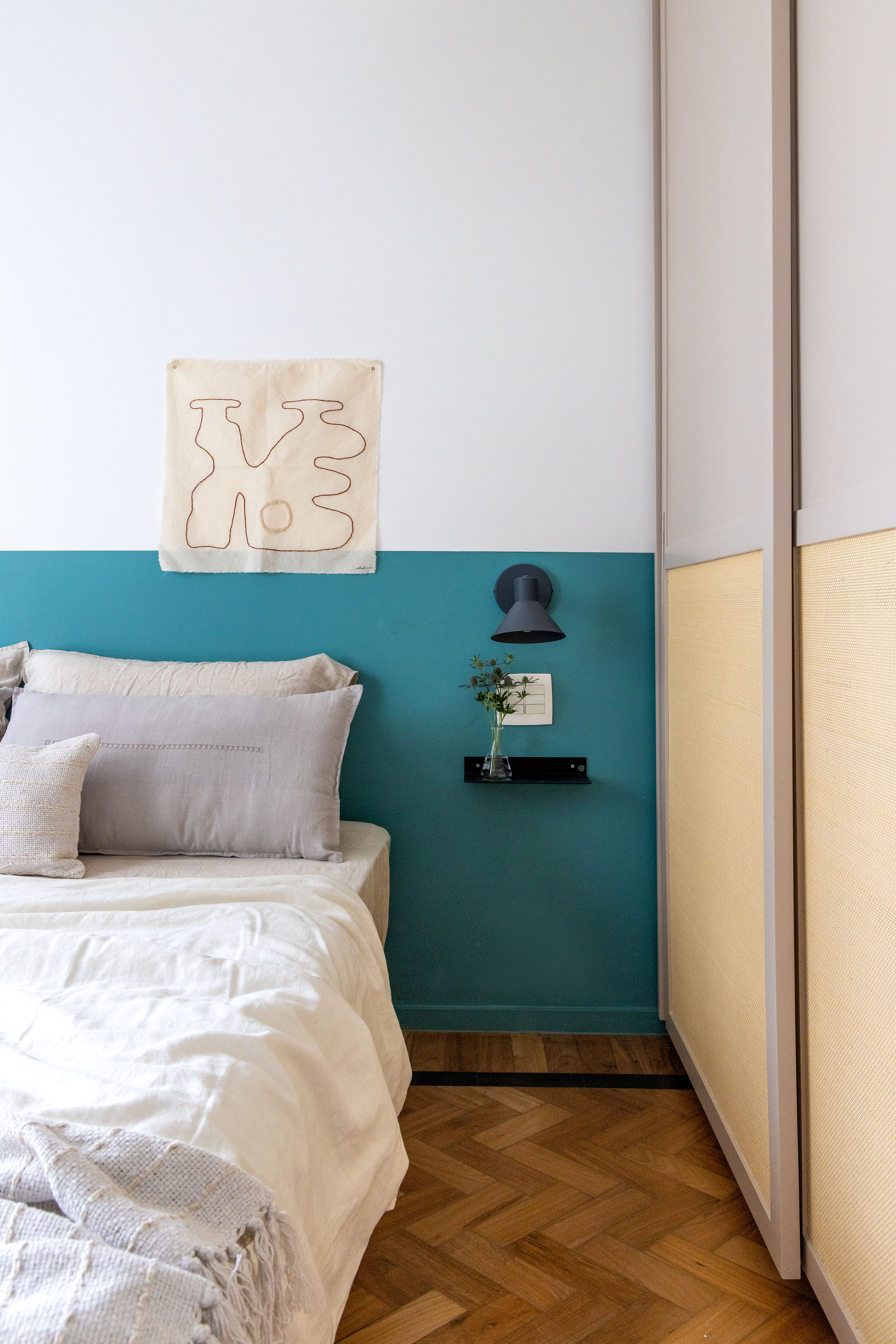 Ladrilhos hidráulicos trazem charme vintage e cor à apê de 90 m². Projeto de Ana Neri. Na foto, quarto de casal, meia parede azul.