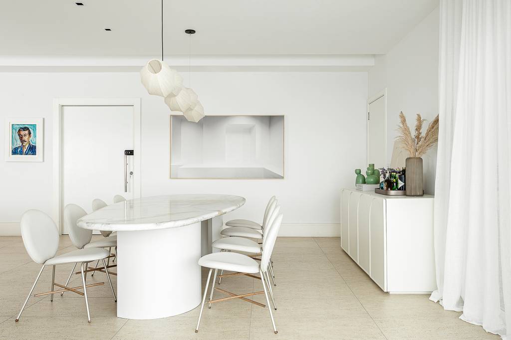 Linhas orgânicas e mobiliário solto compõem décor de apê alugado de 240 m². Projeto de Dubal Arquitetura. Na foto, sala de jantar com quadro e aparador.