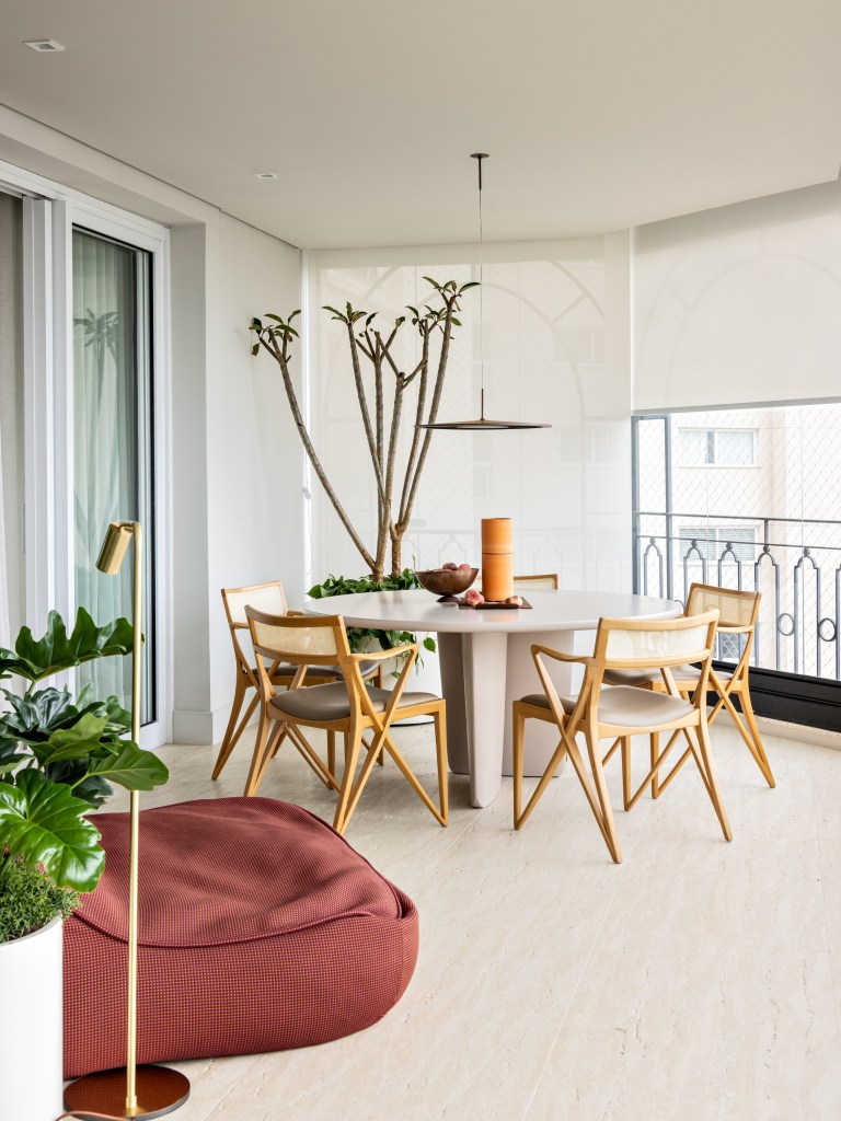 Ripado triangular veste o teto da sala deste apartamento de 450 m². Projeto de Nildo José. Na foto, varanda com mesa de refeições.