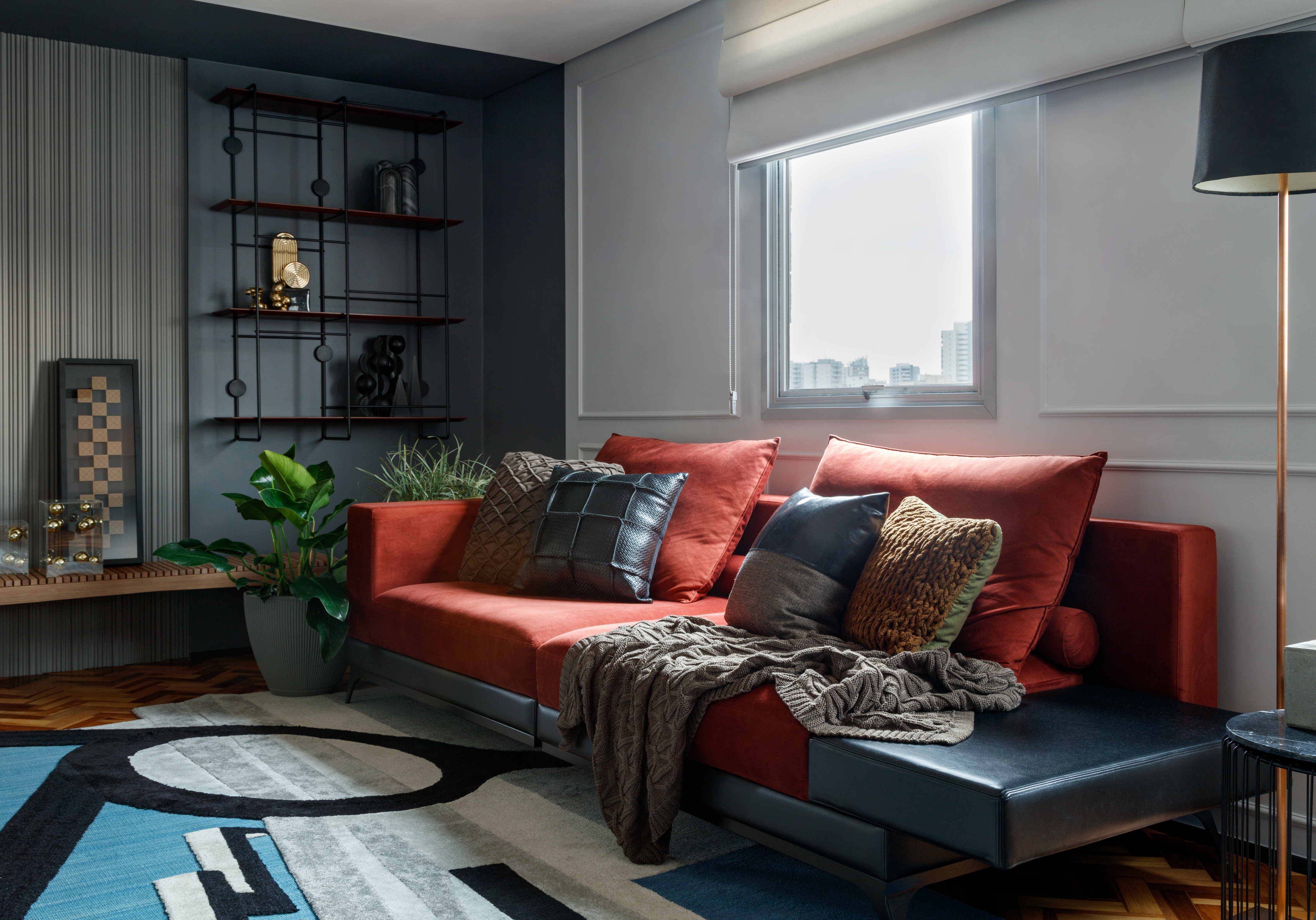 Rústico, retrô e contemporâneo: apê de 72 m² ganha vida com cozinha azul. Projeto de Ricardo Abreu. Na foto, sala de estar com sofá vermelho e parede de porcelanato.