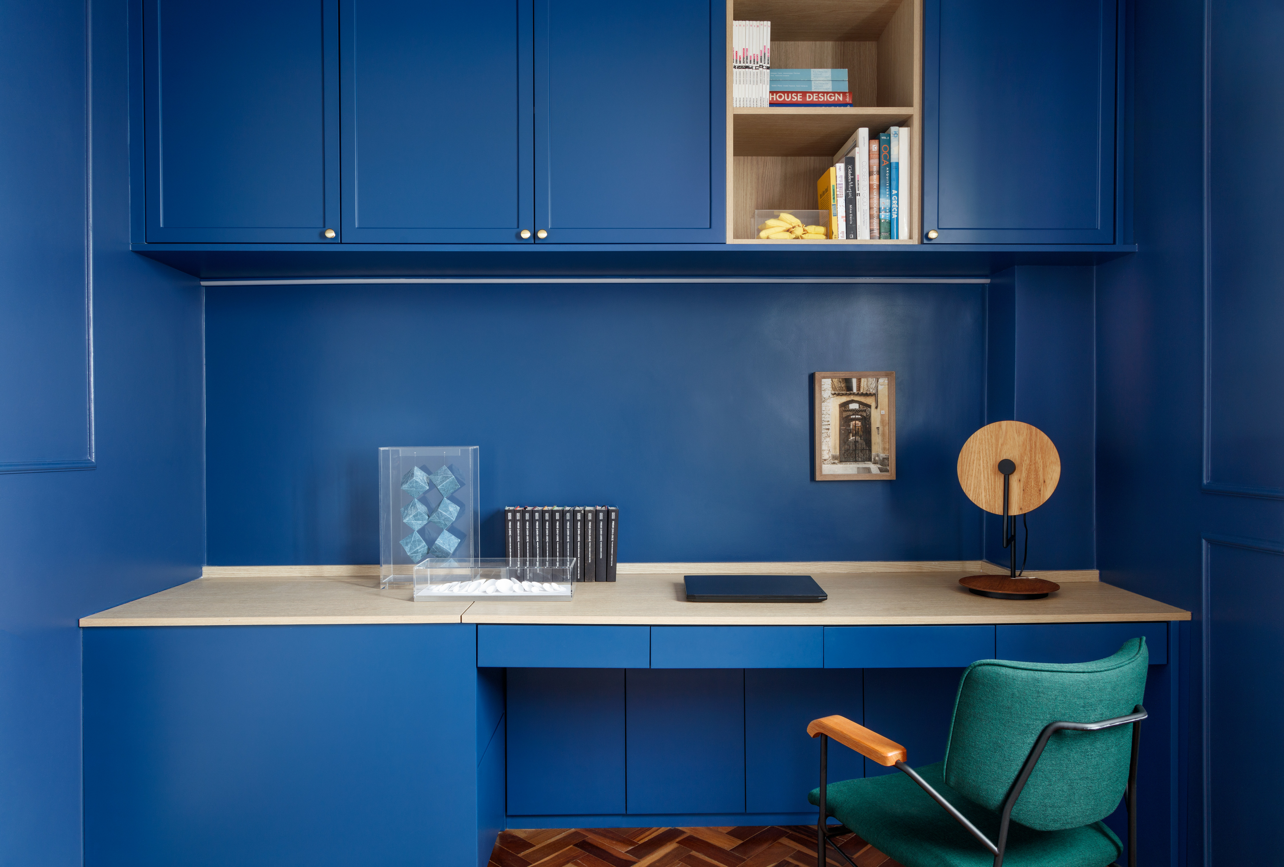 Rústico, retrô e contemporâneo: apê de 72 m² ganha vida com cozinha azul. Projeto de Ricardo Abreu. Na foto, home office com marcenaria azul e cadeira verde.