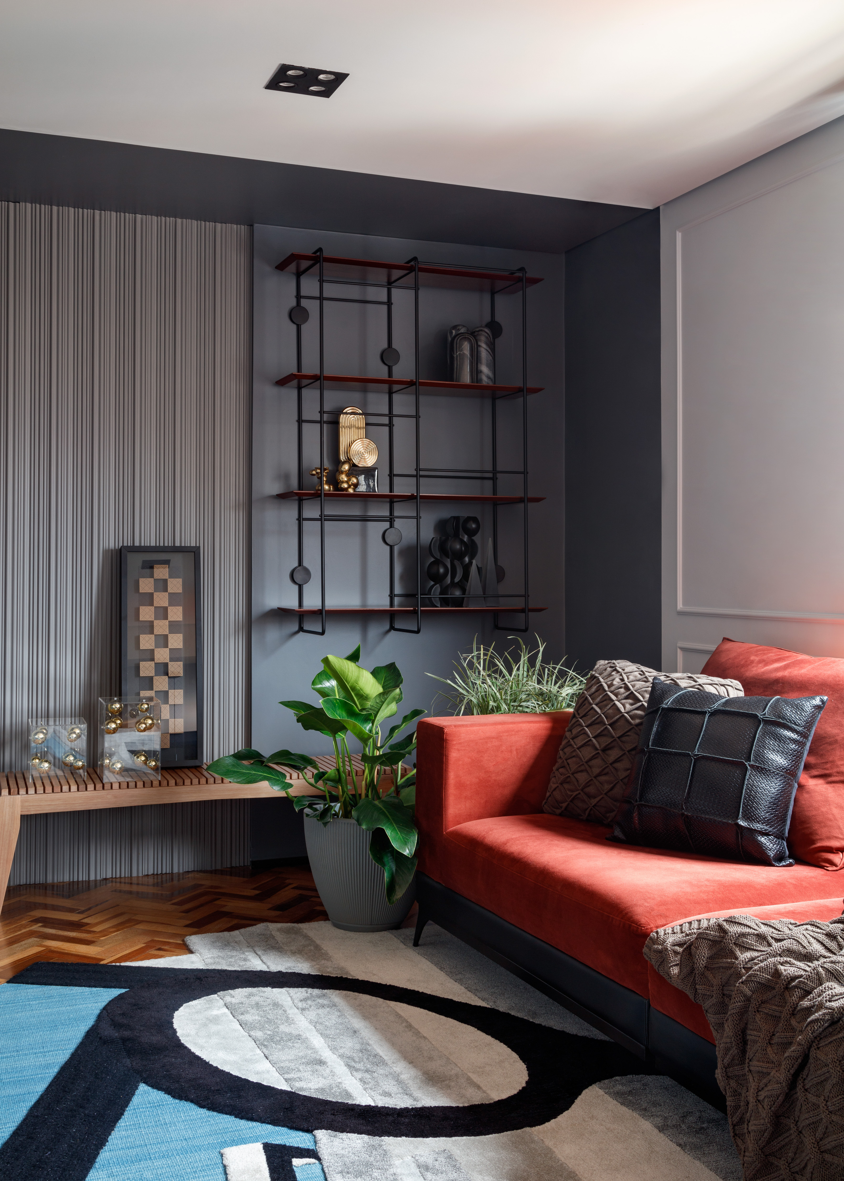 Rústico, retrô e contemporâneo: apê de 72 m² ganha vida com cozinha azul. Projeto de Ricardo Abreu. Na foto, sala de estar com sofá vermelho e parede de porcelanato.