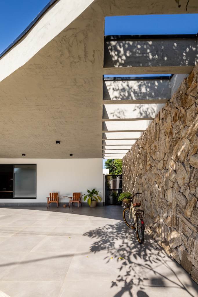 Com sala de jogos e área gourmet ampla, casa de campo vira lar permanente. Projeto de Pietro Terlizzi Arquitetura. Na foto, área externa com muro de pedras.