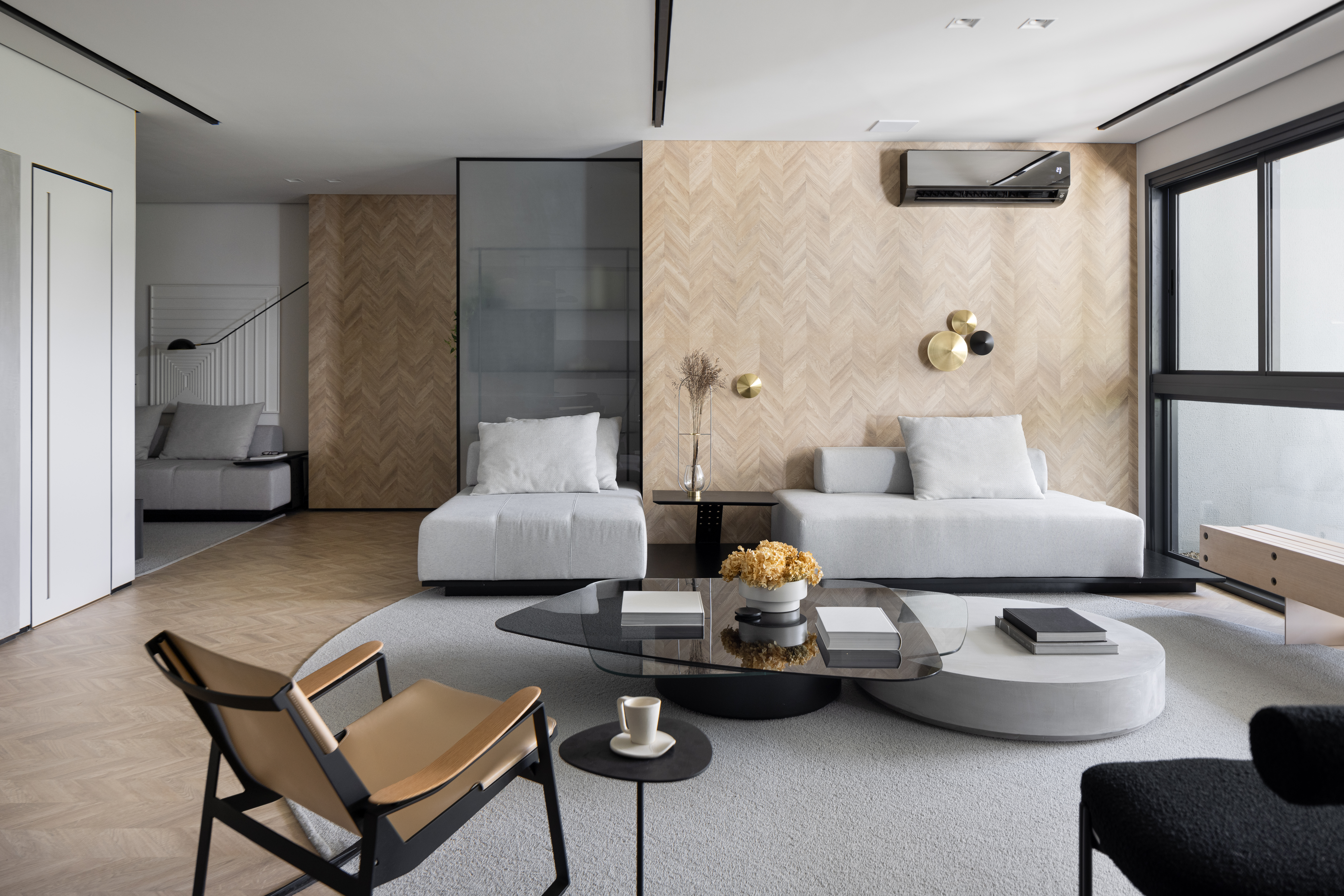 Apê de 142 m² tem paleta elegante de preto e branco e layout integrado. Projeto de Boher Arquitetos. Na foto, sala de estar minimalista, sofá cinza, poltronas, mesa de centro preta.
