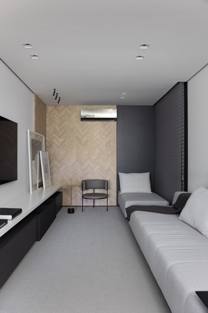Apê de 142 m² tem paleta elegante de preto e branco e layout integrado. Projeto de Boher Arquitetos. Na foto, sala íntima minimalista, sofá cinza e tv.