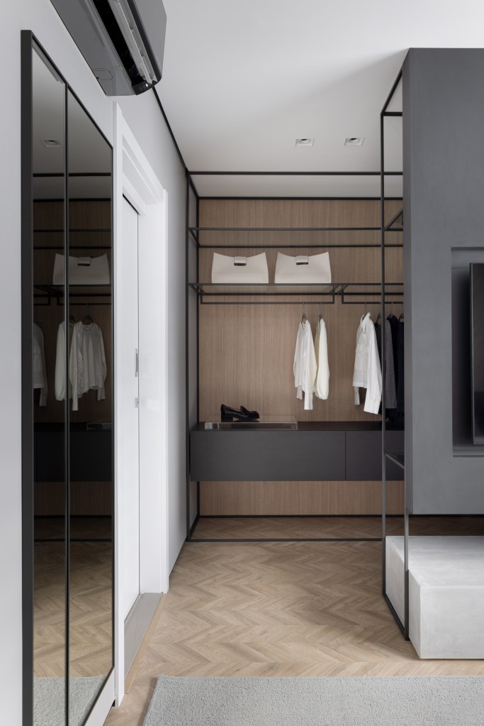 Apê de 142 m² tem paleta elegante de preto e branco e layout integrado. Projeto de Boher Arquitetos. Na foto, closet walk-in, armários e prateleiras pretas.