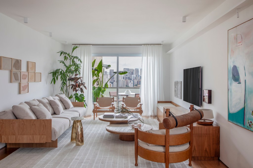 Apê de 180 m² com sala íntima equilibra minimalismo e conforto. Projeto de Studio LAK. Na foto, sala de estar neutra com sofá off white