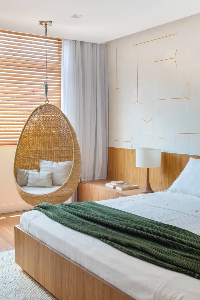 Apê de 300 m² tem sala íntima com TV e cozinha com armários amarelos. Projeto de PKB Arquitetura. Na foto, quarto de casal com parede de azulejos, cabeceira de madeira e balanço ao lado da cama.