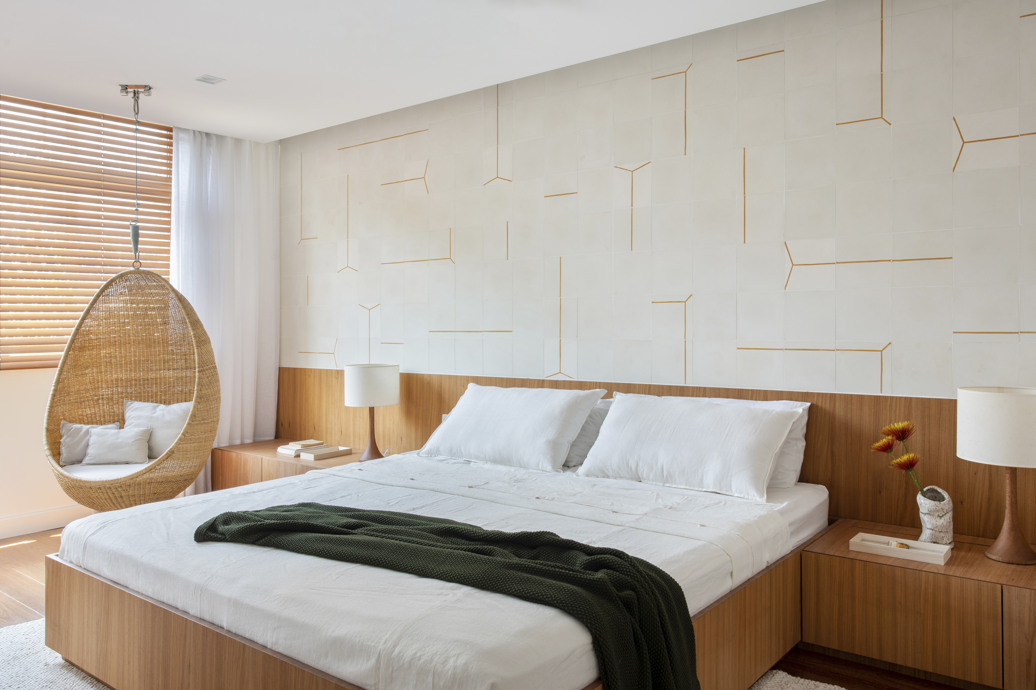 Apê de 300 m² tem sala íntima com TV e cozinha com armários amarelos. Projeto de PKB Arquitetura. Na foto, quarto de casal com parede de azulejos, cabeceira de madeira e balanço ao lado da cama.