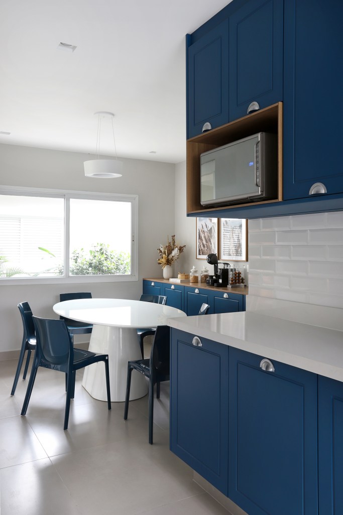 Área gourmet aconchegante é a protagonista desta casa de campo de 600 m². Projeto de Almada Arquitetura. Na foto, cozinha com marcenaria azul e subway tiles.