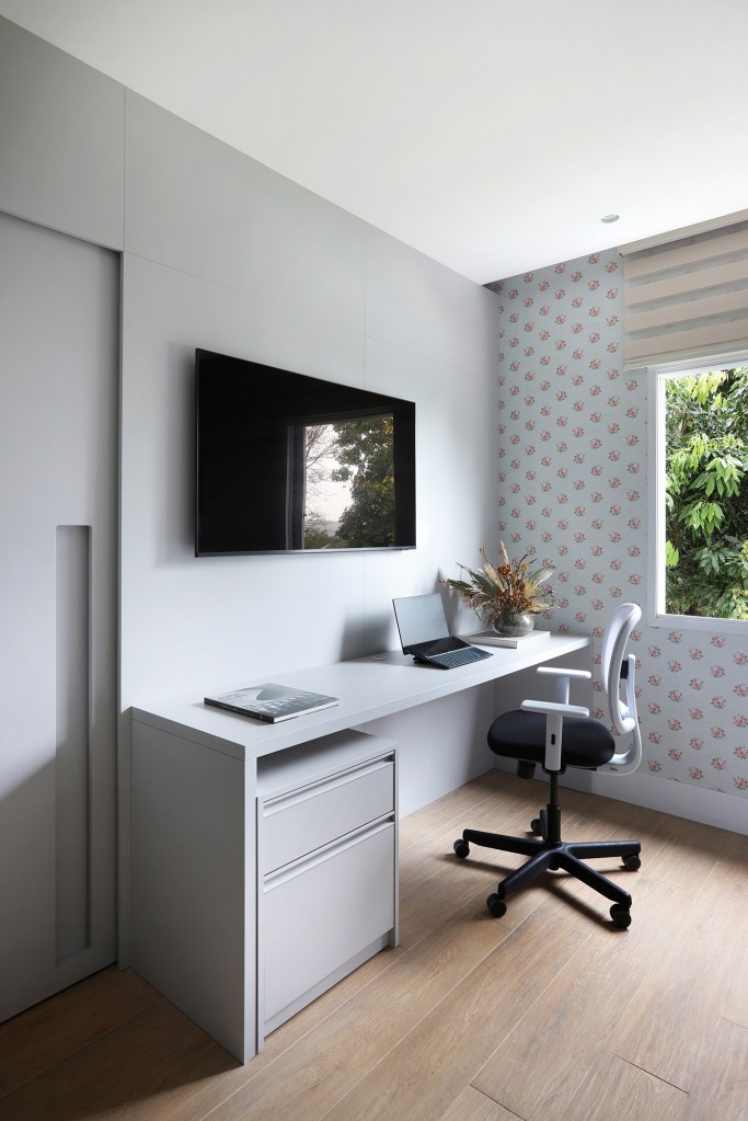 Área gourmet aconchegante é a protagonista desta casa de campo de 600 m². Projeto de Almada Arquitetura. Na foto, home office com tv e papel de parede.