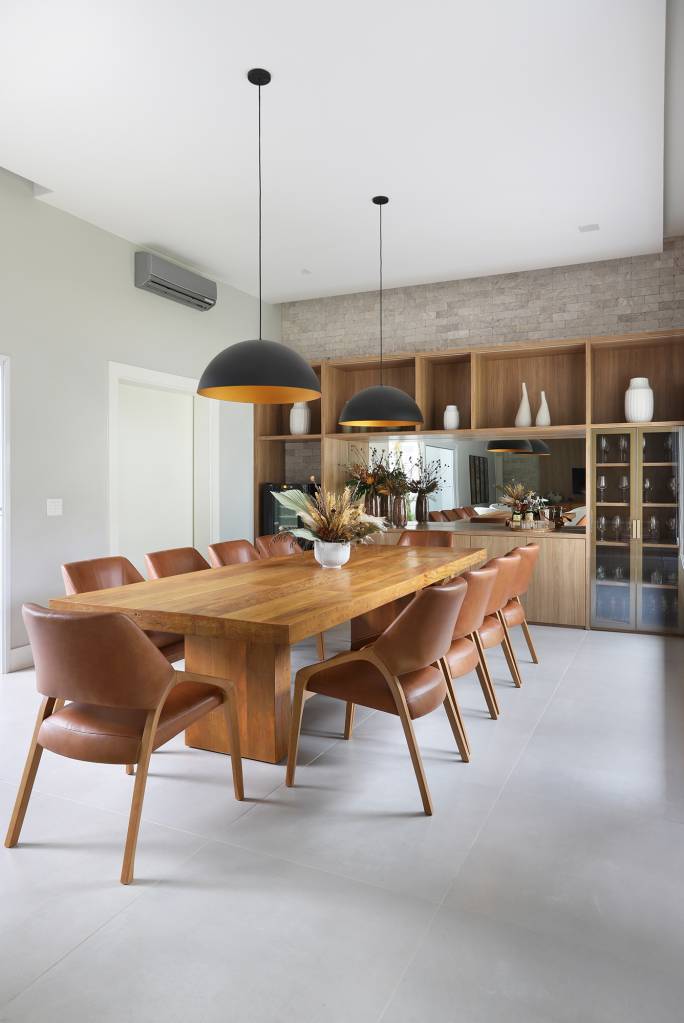 Área gourmet aconchegante é a protagonista desta casa de campo de 600 m². Projeto de Almada Arquitetura. Na foto, área gourmet com adega, aparador e estante.