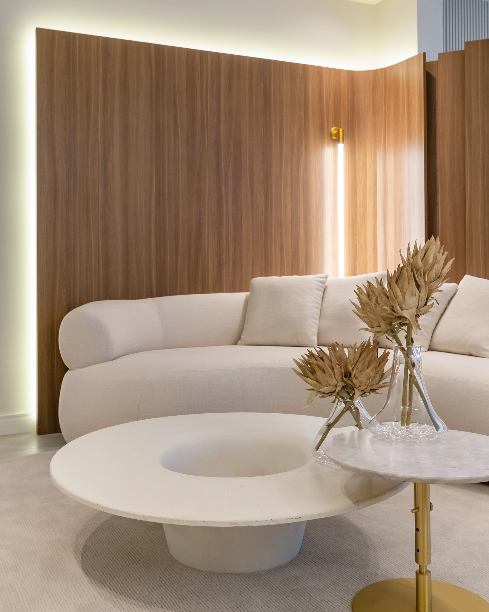 Descubra as características do Old Money e Quiet luxury na decoração. Na foto, sala de estar com sofá branco curvo, mesa de centro.