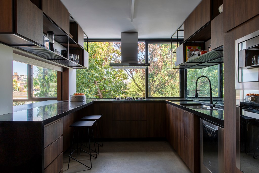 Casa dos anos 1950 ganha novo projeto que preserva a arquitetura original, Projeto de Conrado Ceravolo. Na foto, cozinha com vista para o jardim.