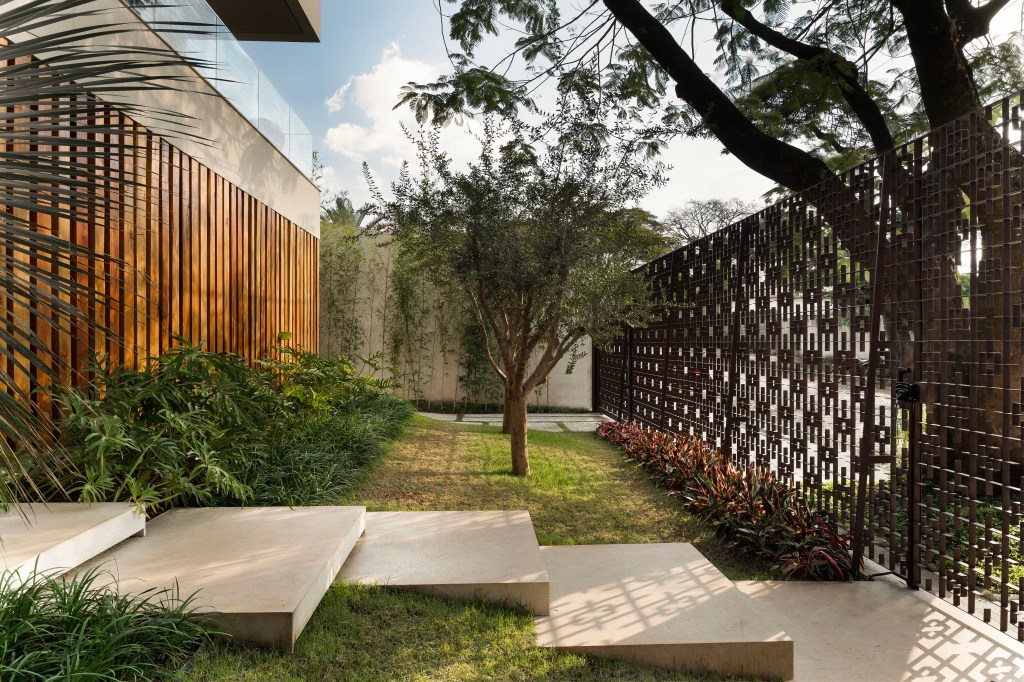 Casa integrada ao jardim e tem painel de azulejos de Alexandre Mancini. Projeto de Rogério da Fonseca. Na foto, fachada, jardim, gramado.