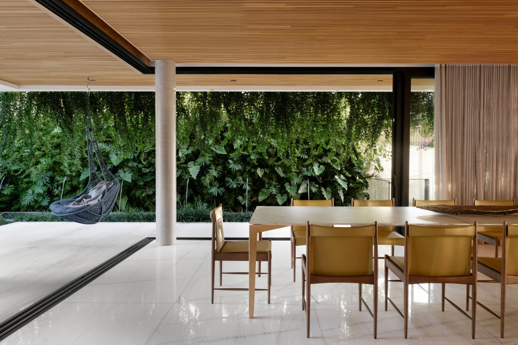 Casa integrada ao jardim e tem painel de azulejos de Alexandre Mancini. Projeto de Rogério da Fonseca. Na foto, cozinha, piso de mármore, jardim, cristaleira.