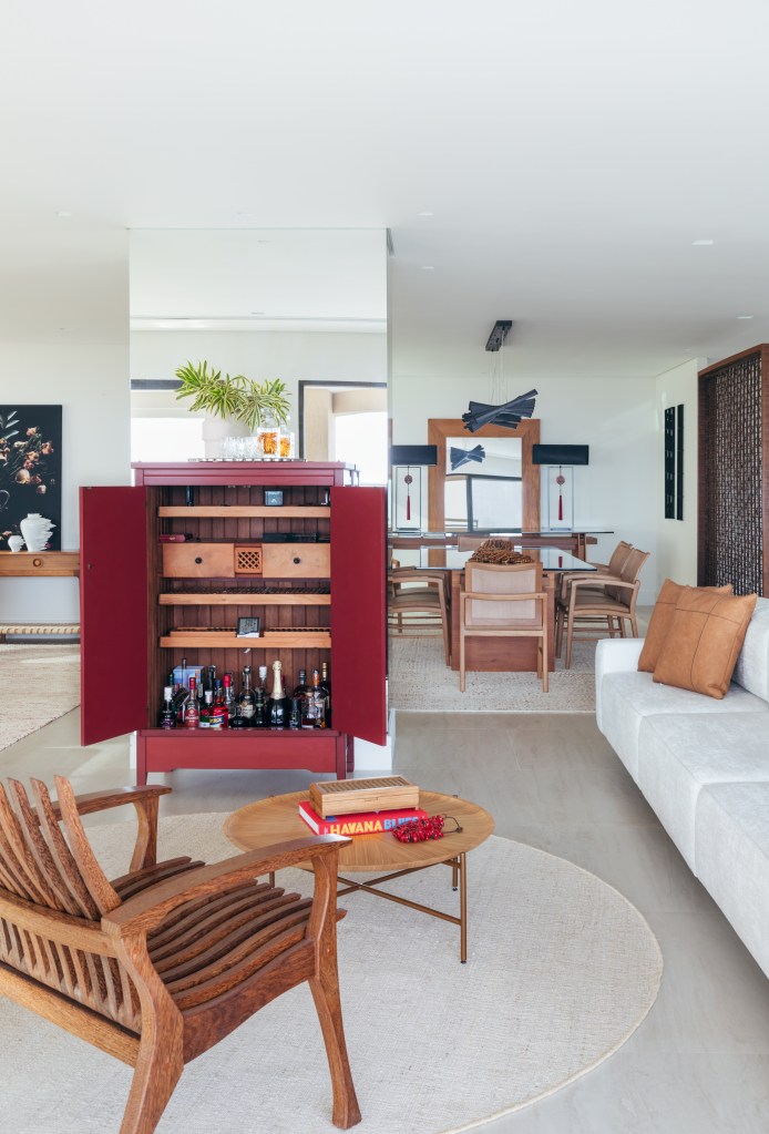 Cobertura tem sauna com paredes de vidro e área gourmet com balanços. Projeto de Vivian Reimers. Na foto, armário vermelho aberto, cadeira de madeira.