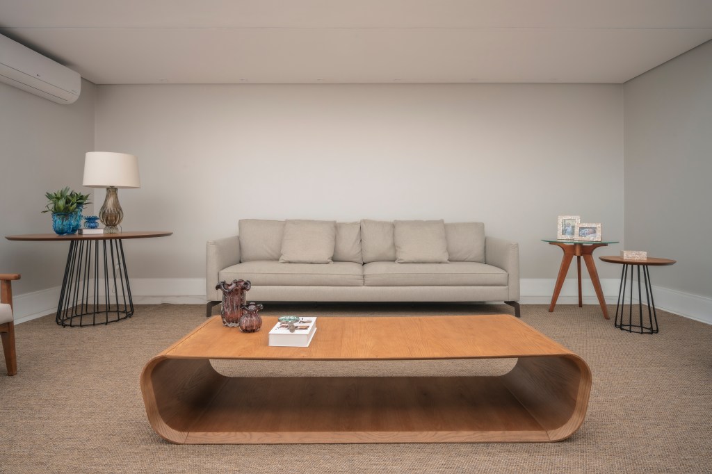 Com 500 m², casa clean tem paleta clara, closet e cozinha provençal. Projeto de PB Arquitetura. Na foto, sala minimalista, sofá bege, mesa de centro de madeira, tapete bege.